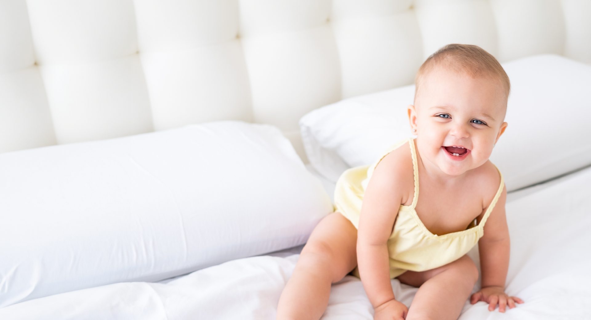 laughing baby girl in yellow dress